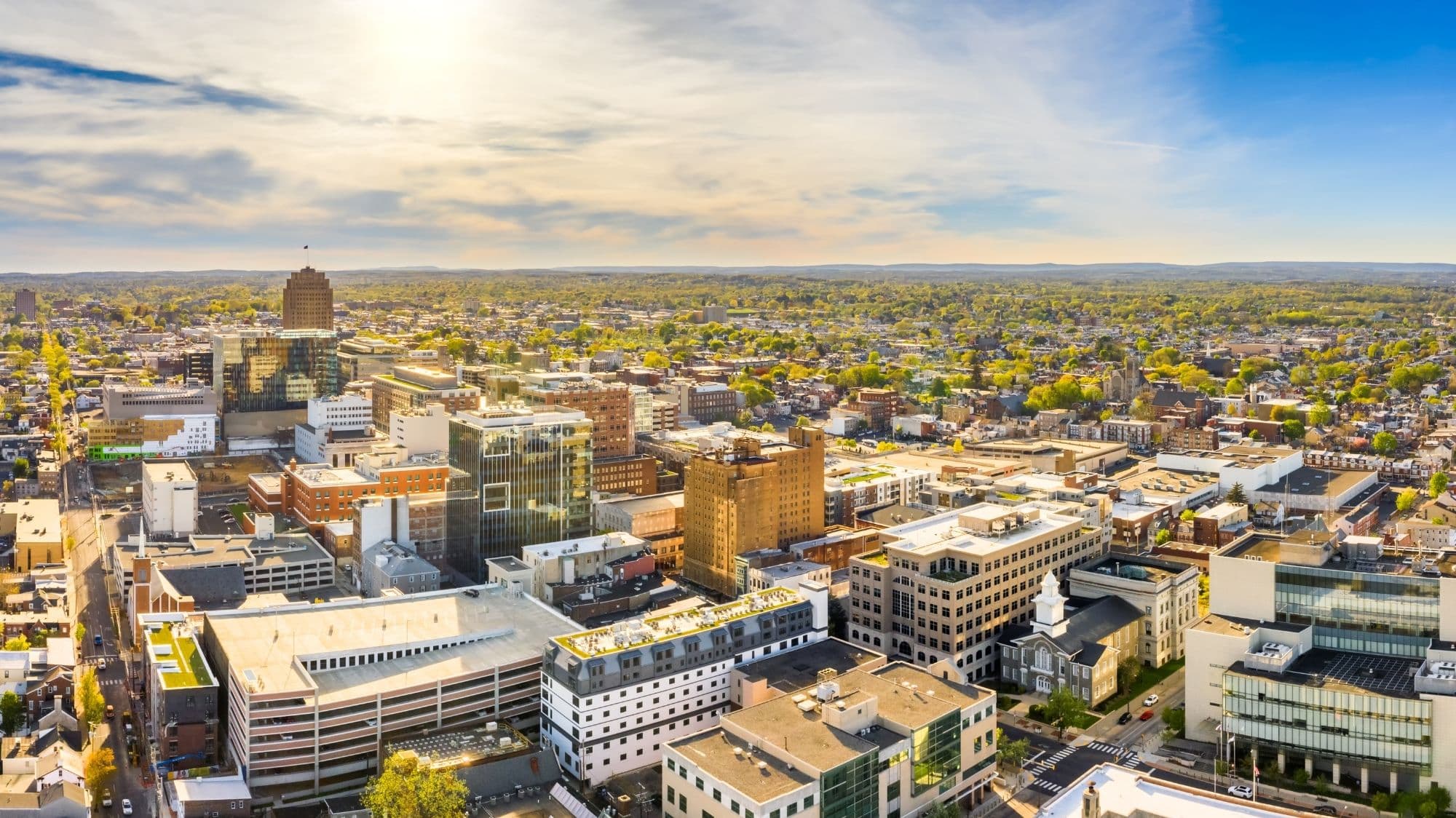 Aerial view of downtown Allentown, Pennsylvania, with office towers and neighborhoods stretching toward distant hills