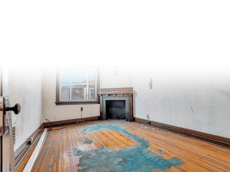 Empty room of a house with water-damaged wooden floor